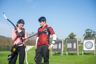 Man and Woman Looking at Bow Archery Equipment